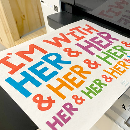 A printed sign reading "I'm With Her & Her & Her & Her & Her & Her & Her & Her & Her...